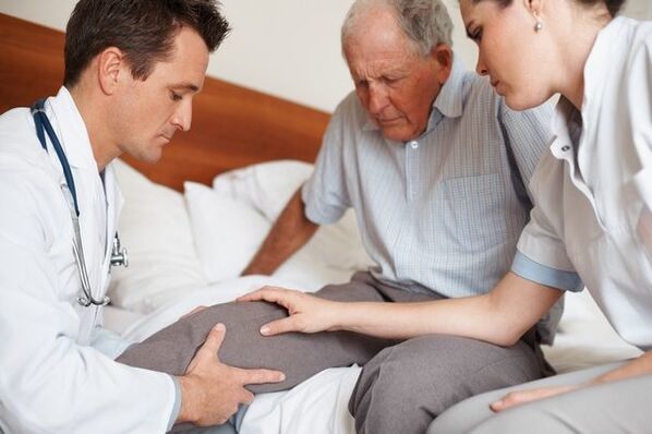 Médico examinando o xeonllo do paciente